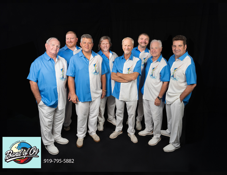 eight members of the band of oz wearing blue and white matching shirts.